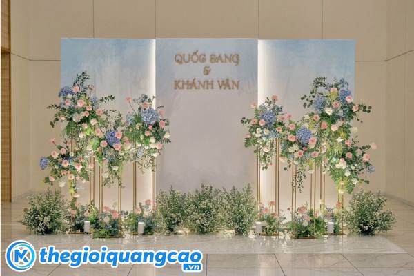 Mẫu backdrop check in kết hợp trang tr&iacute; hoa tươi