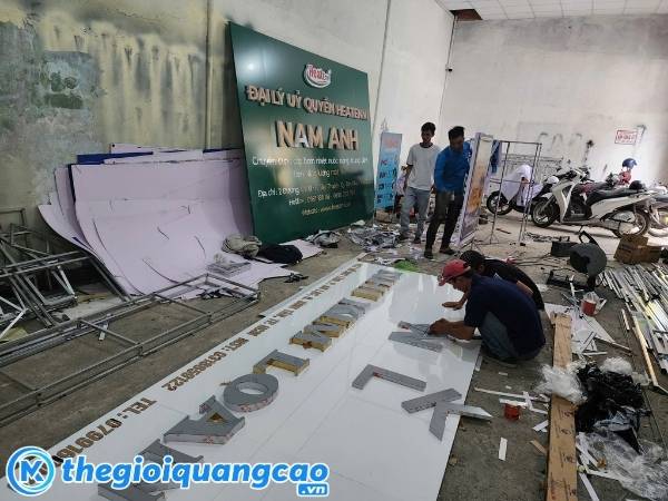 Đội ngũ thi c&ocirc;ng đang lắp r&aacute;p bảng hiệu tại xưởng